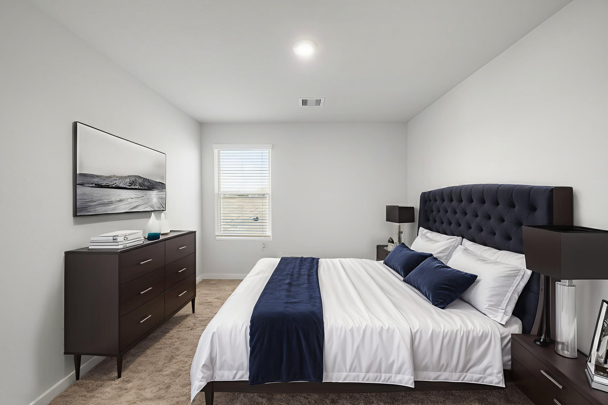 A bedroom with a bed and dresser.