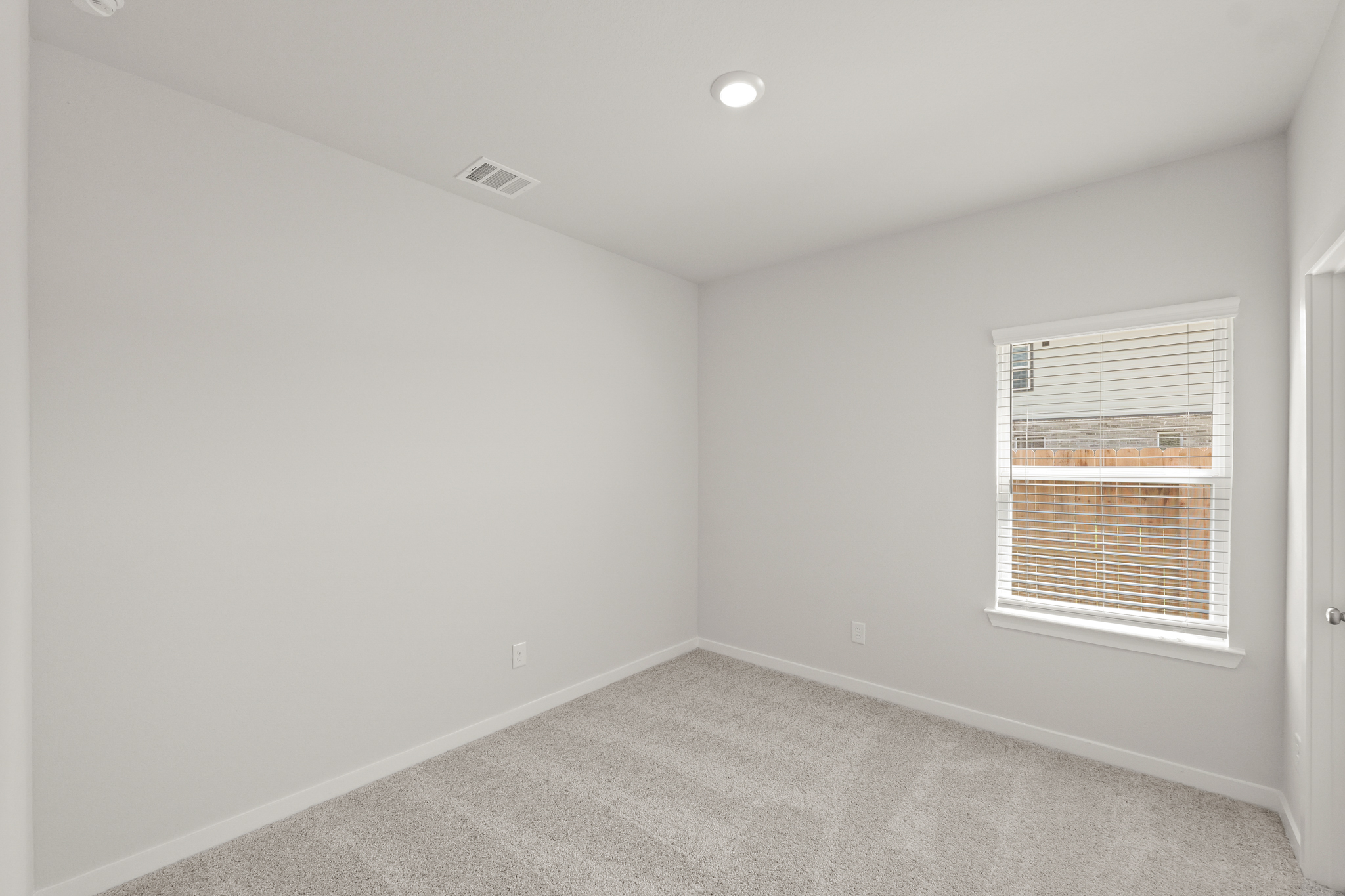 A room with a window and a carpet.