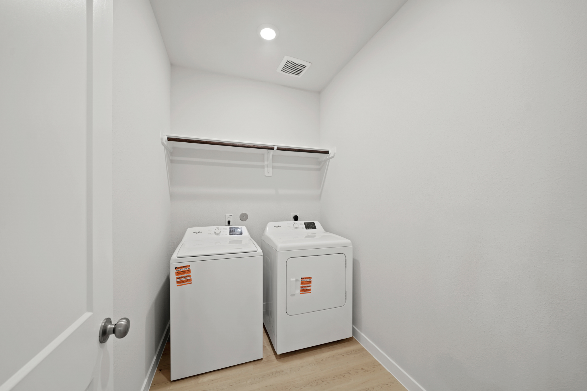 A white room with a washing machine and a white door.
