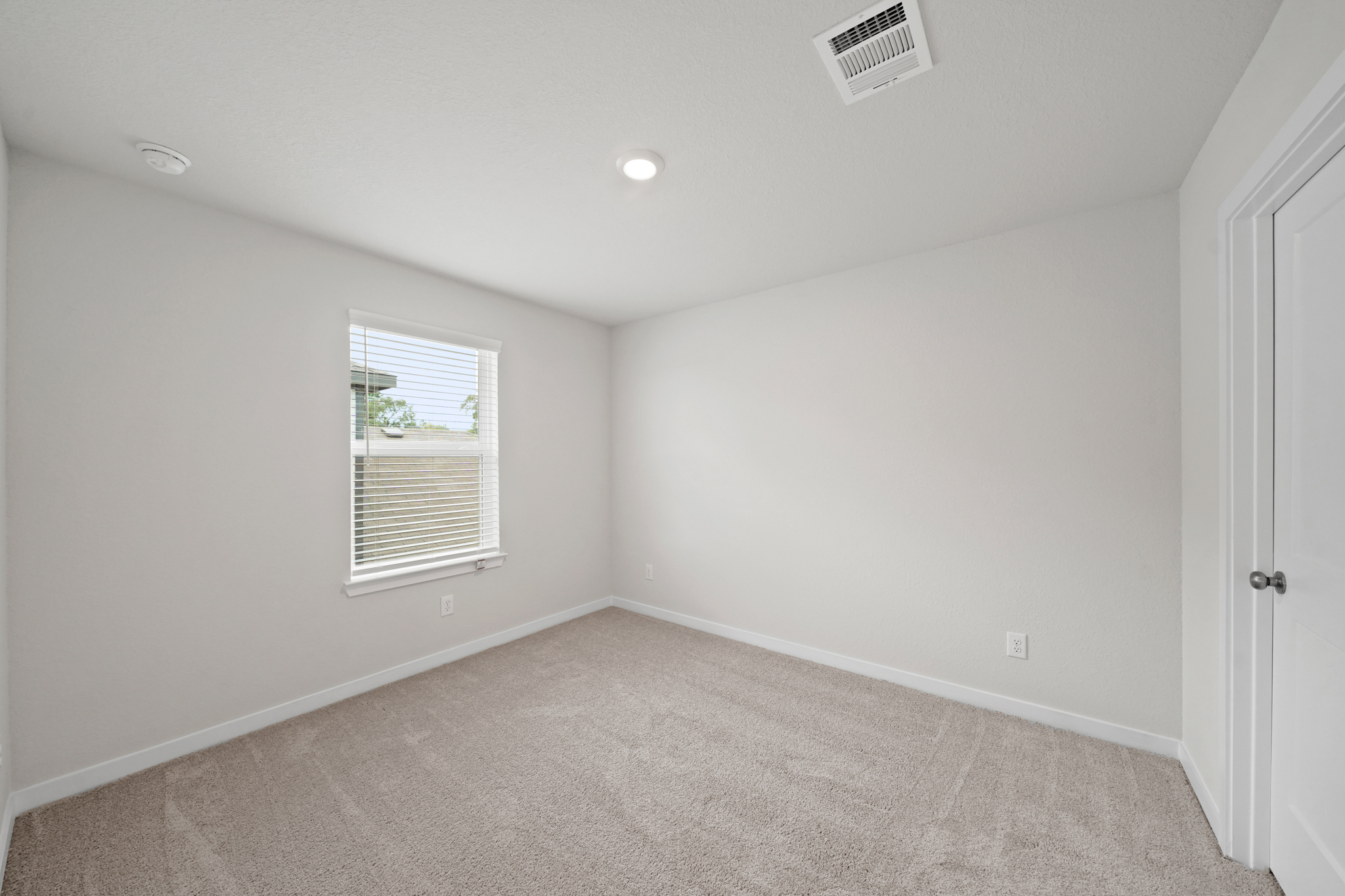 A room with a carpet and a window.