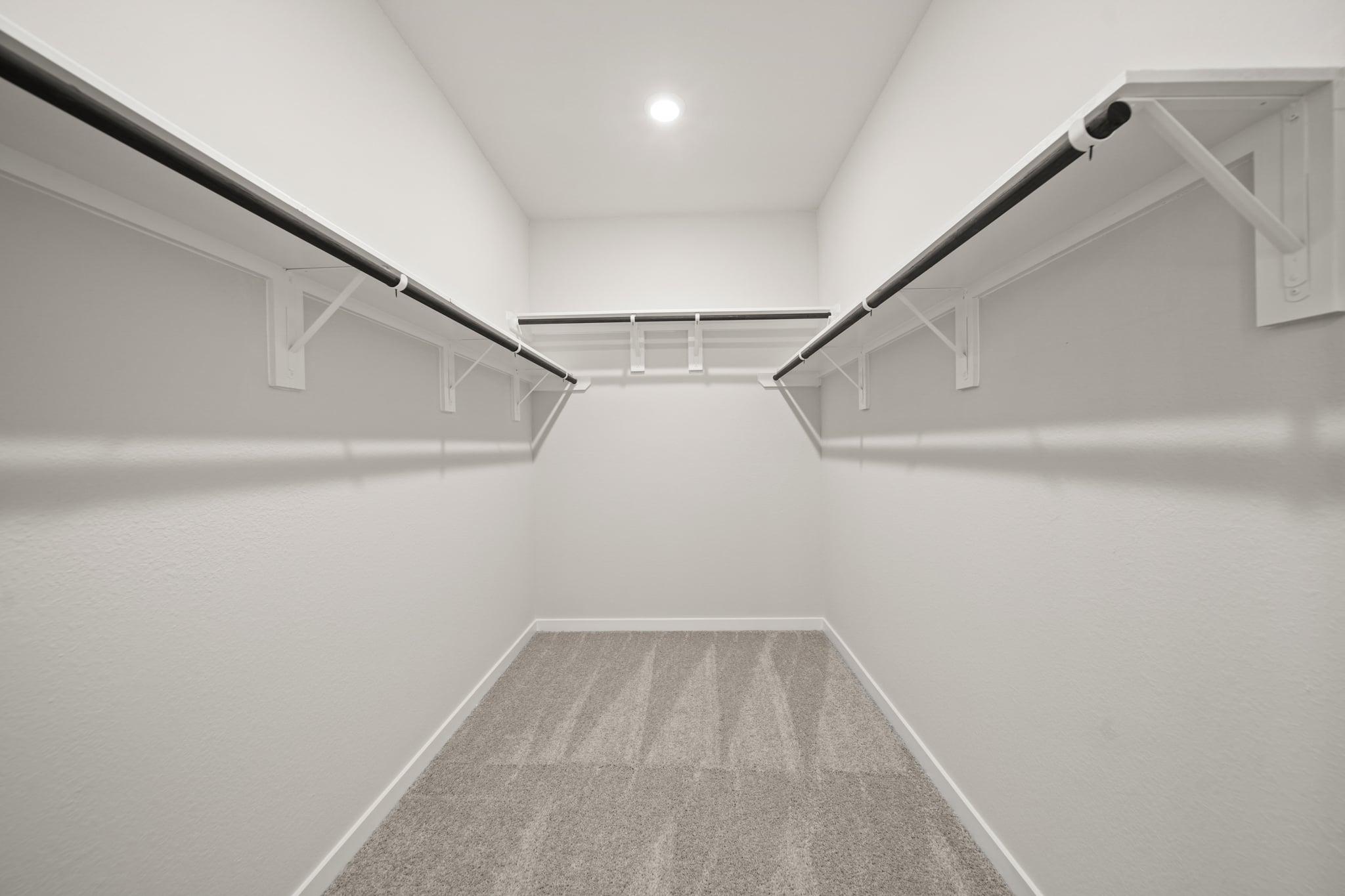 A white hallway with a grey carpet.