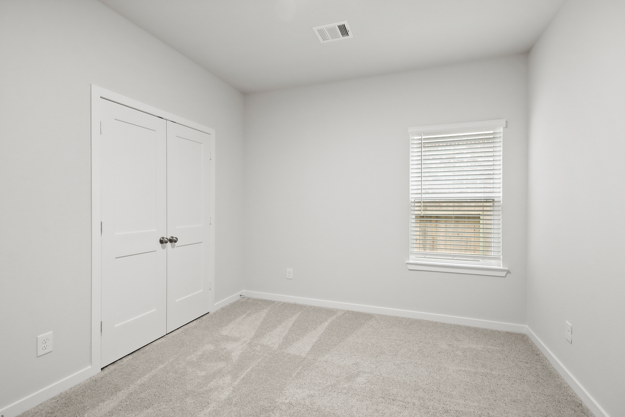 A room with white walls and a window.