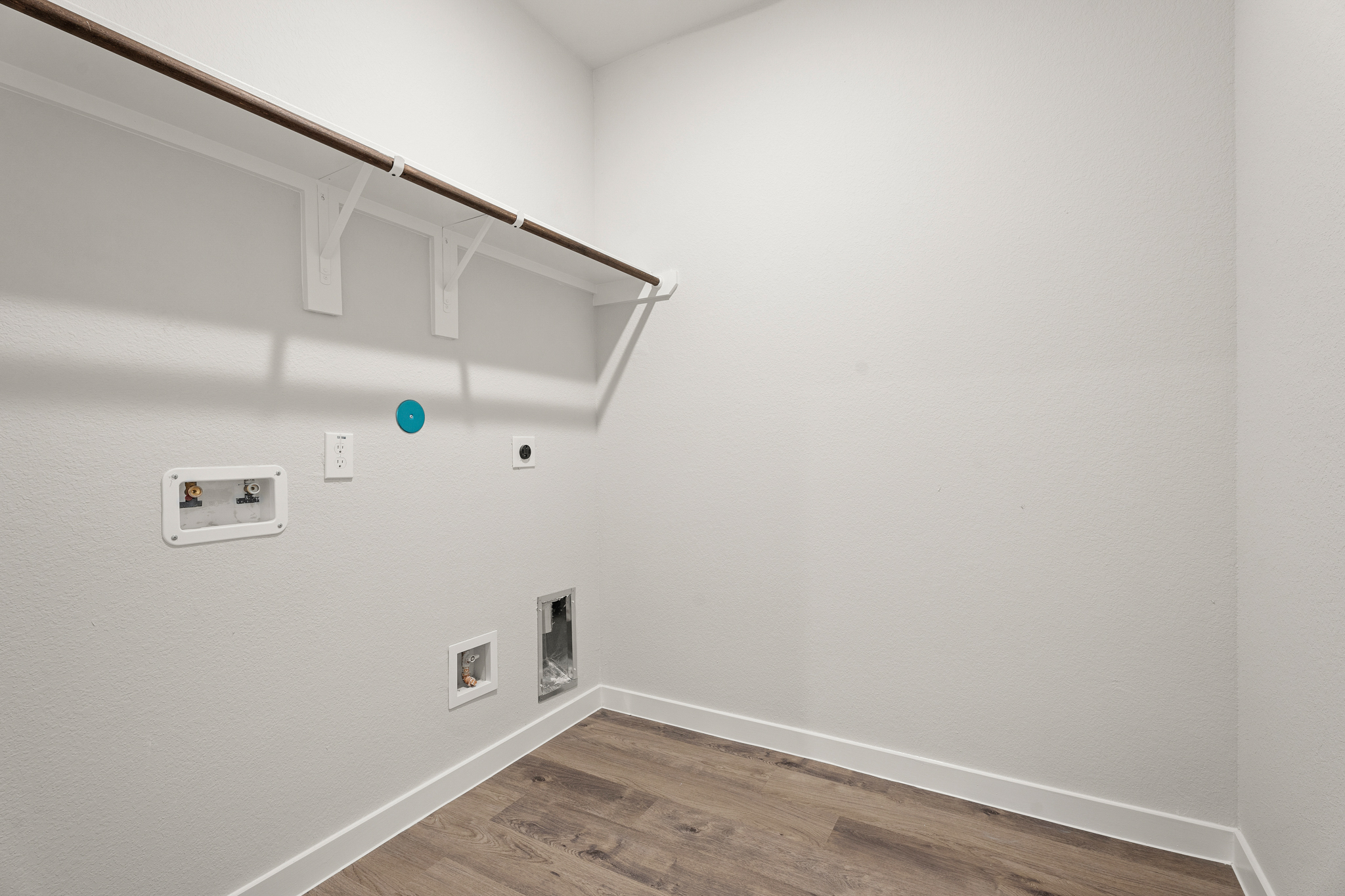 A white room with a wood floor and white walls.