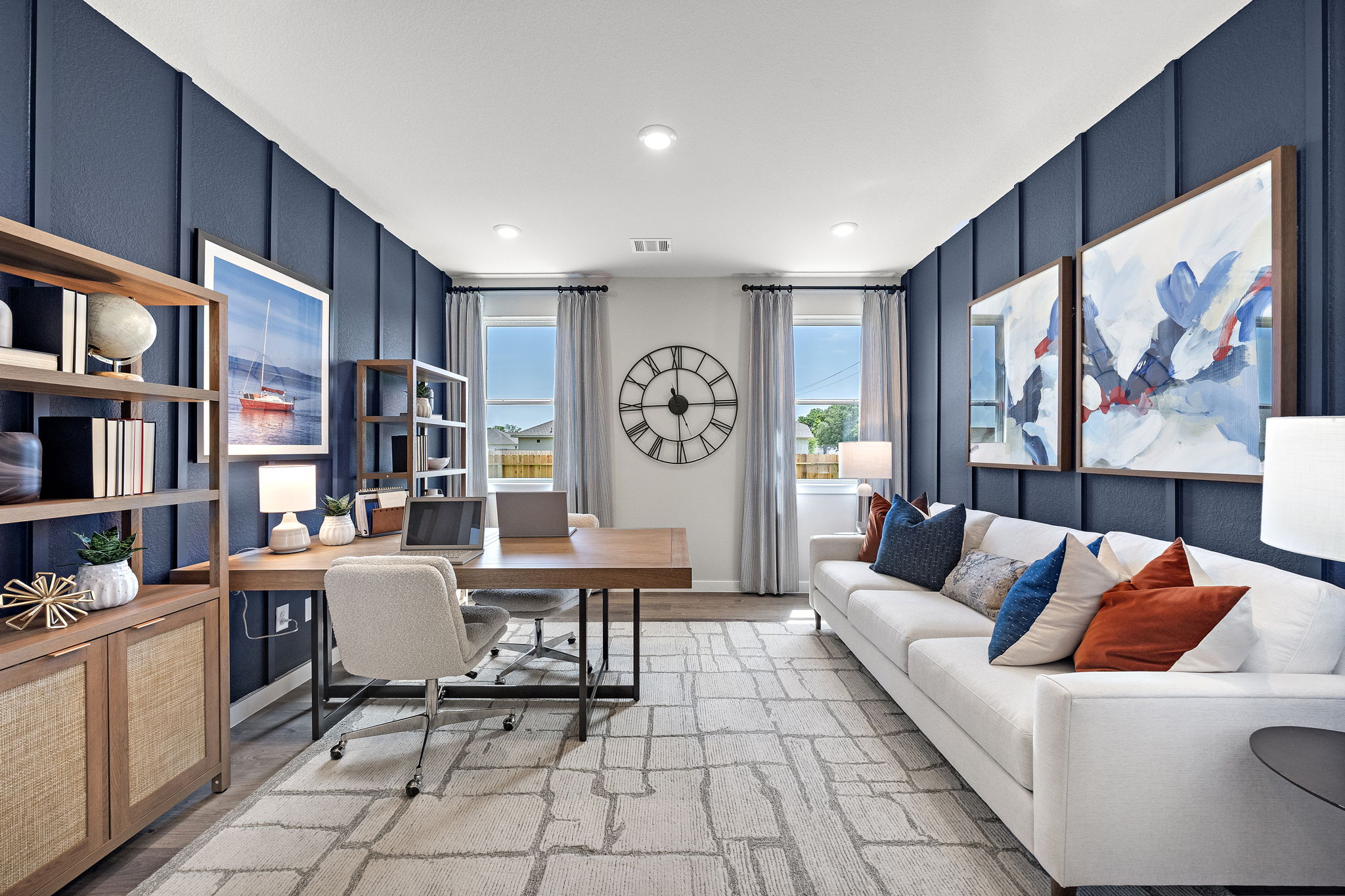 A living room with a desk and a couch.