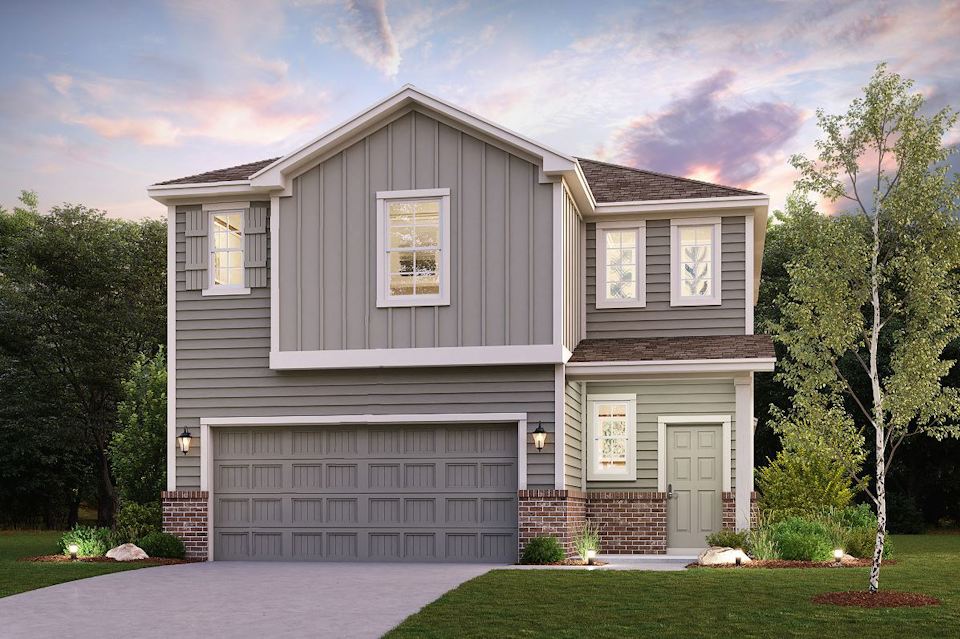 A grey house with trees and grass.