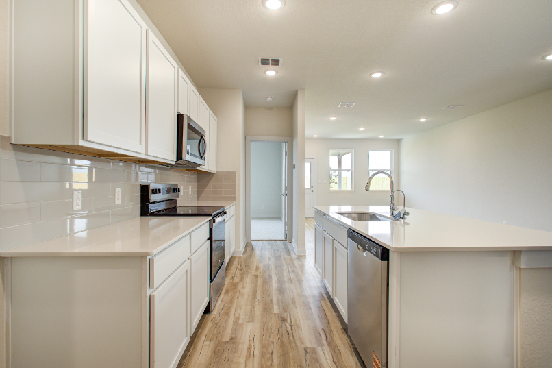 A kitchen with white cabinets.