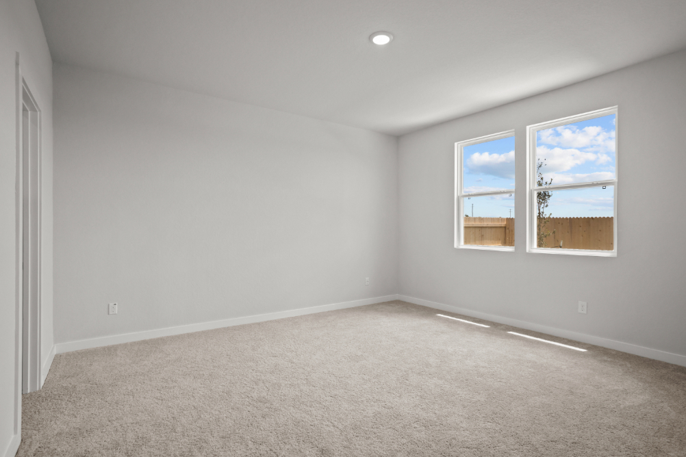 A room with a window and a painting on the wall.