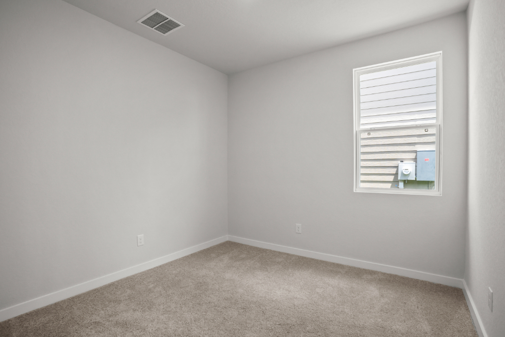 A room with a window and a carpet.