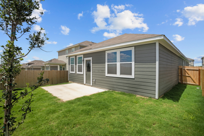 A house with a fence and grass.