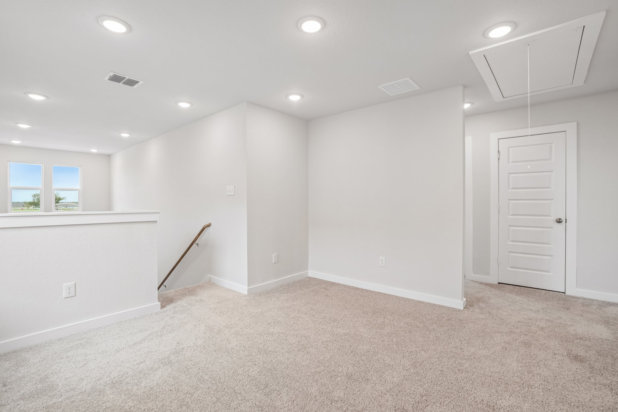 A room with white walls and a broom in it.