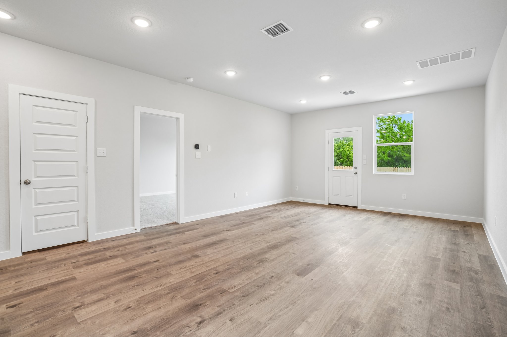 A room with white walls and a wood floor.