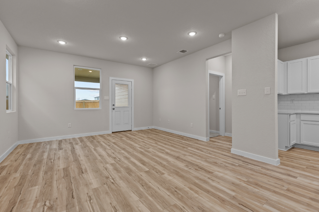 A room with white walls and wood floors.