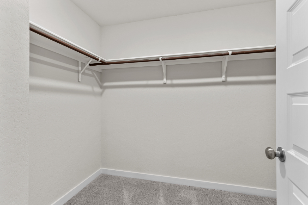 A white wall with a metal bar.