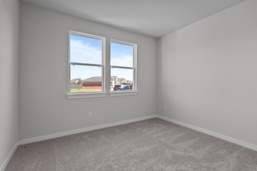 A room with a window and a carpet.