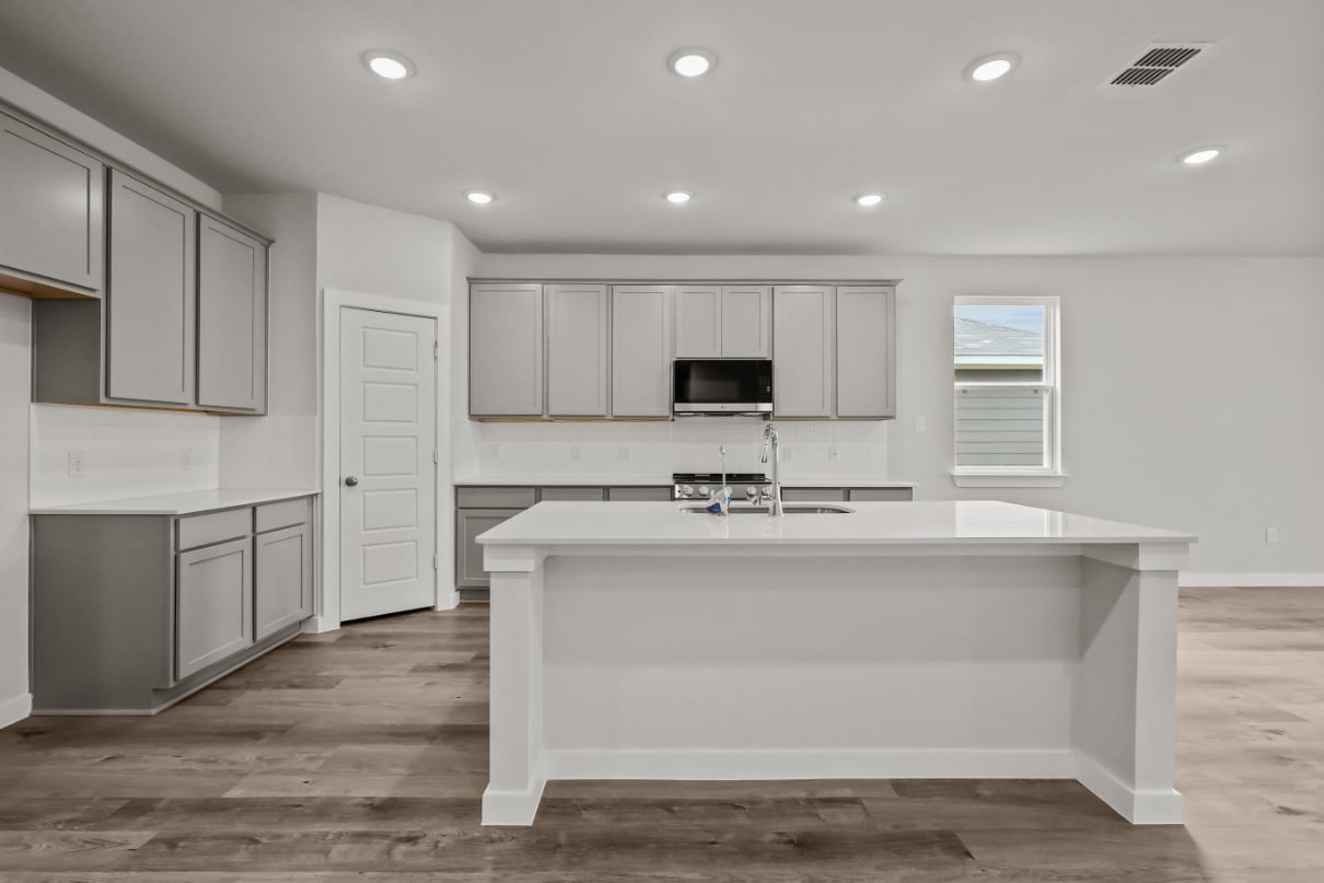 A kitchen with white cabinets.
