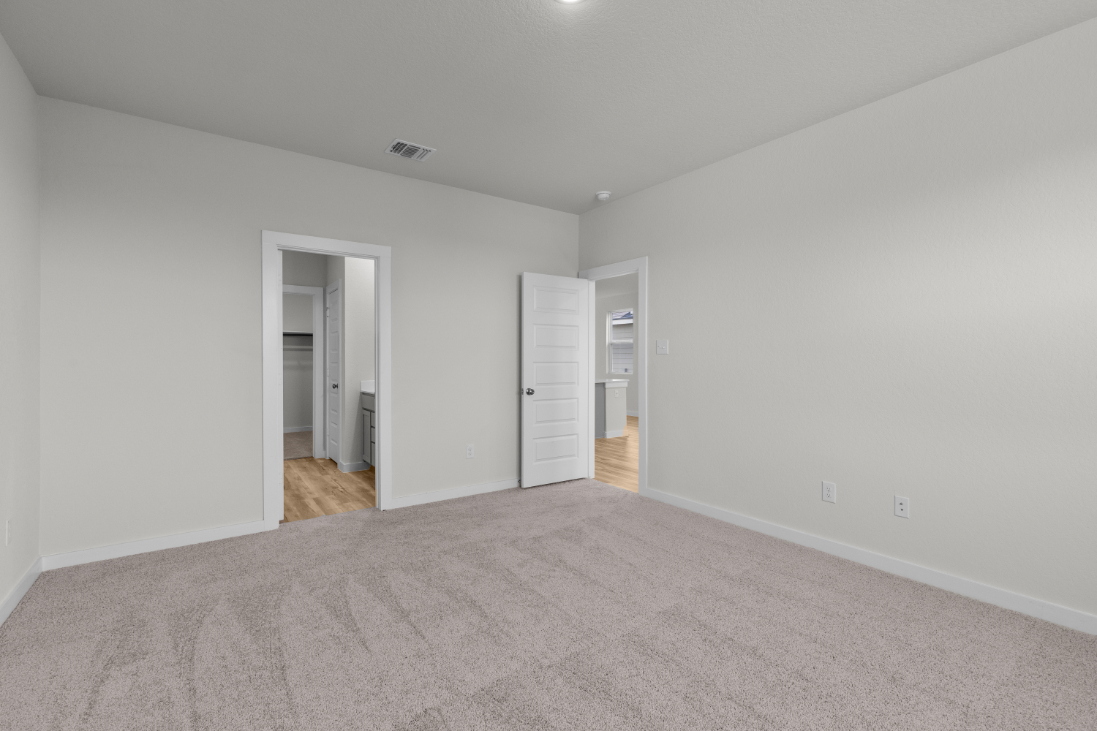 A room with a carpet and a door.