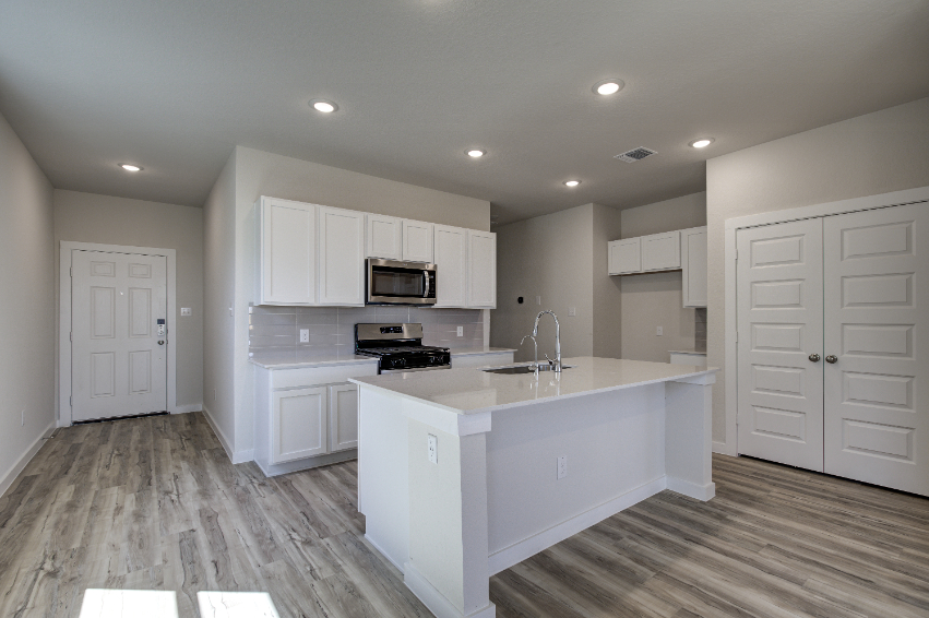 A kitchen with white cabinets.