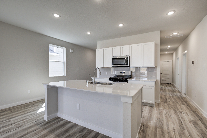 A kitchen with white cabinets.
