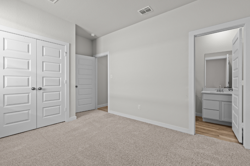 A bathroom with white cabinets.