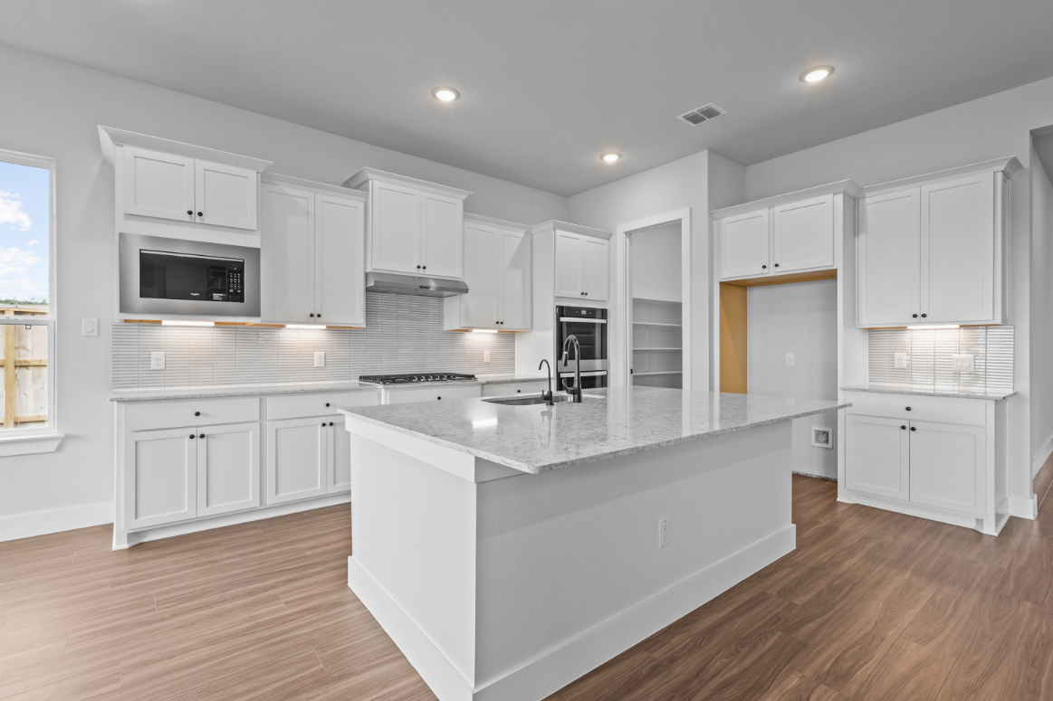 A kitchen with white cabinets.