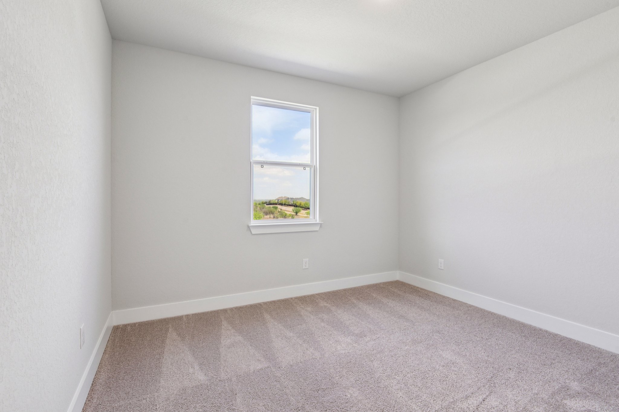 A room with a window and a carpet.