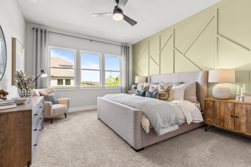 A bedroom with a bed and a chair.