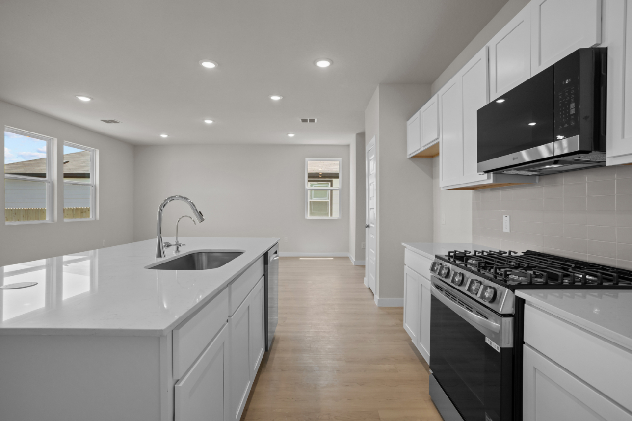 A kitchen with white cabinets.