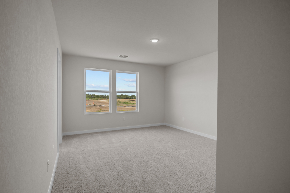 A room with a window and a carpet.