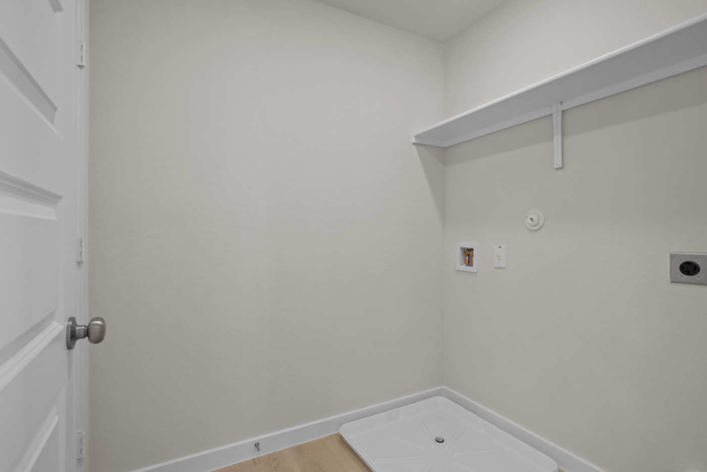 A white wall with a white door.