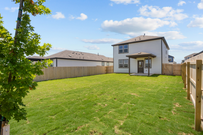A house with a fence and grass.