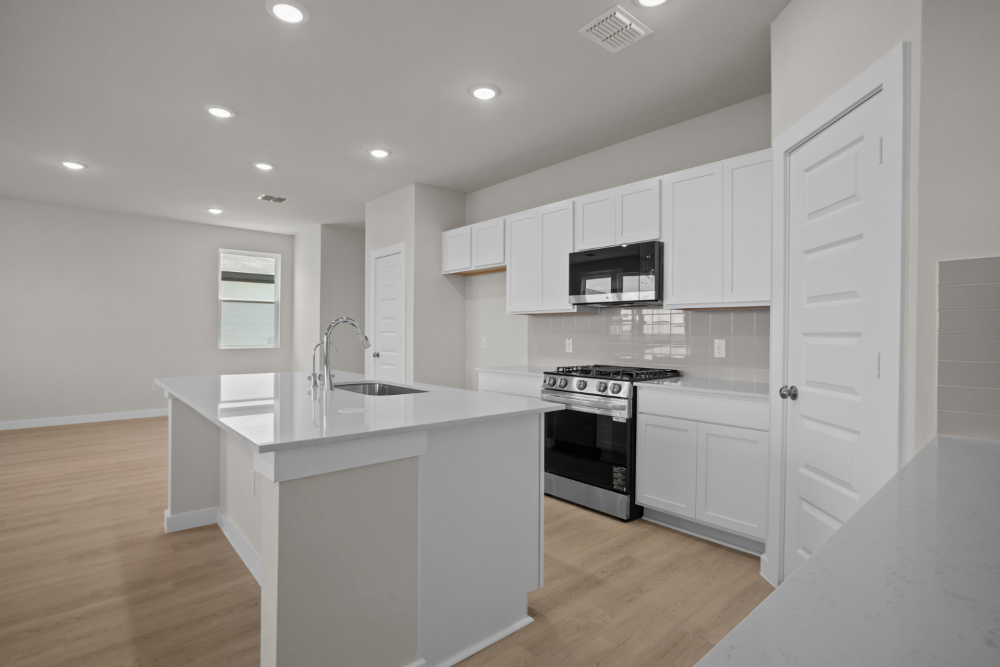 A kitchen with white cabinets.