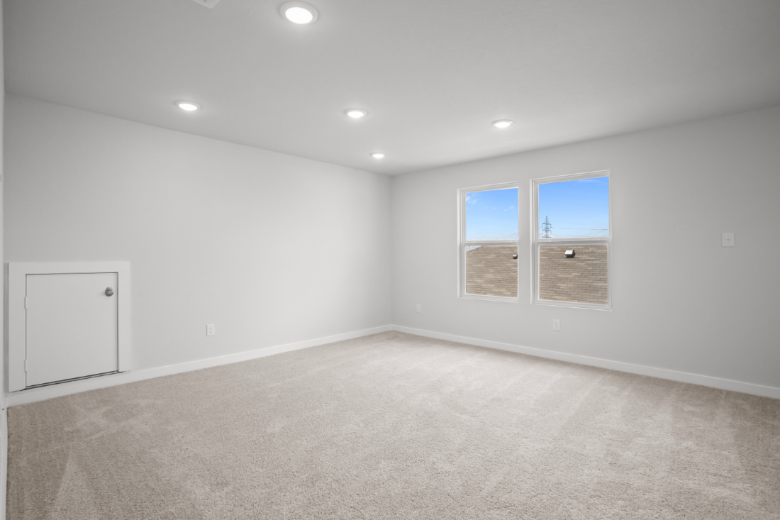 A room with a white wall and windows.