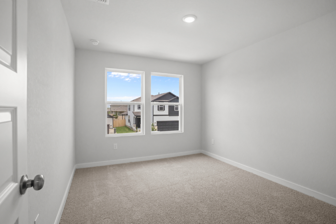 A room with a window and a carpet.