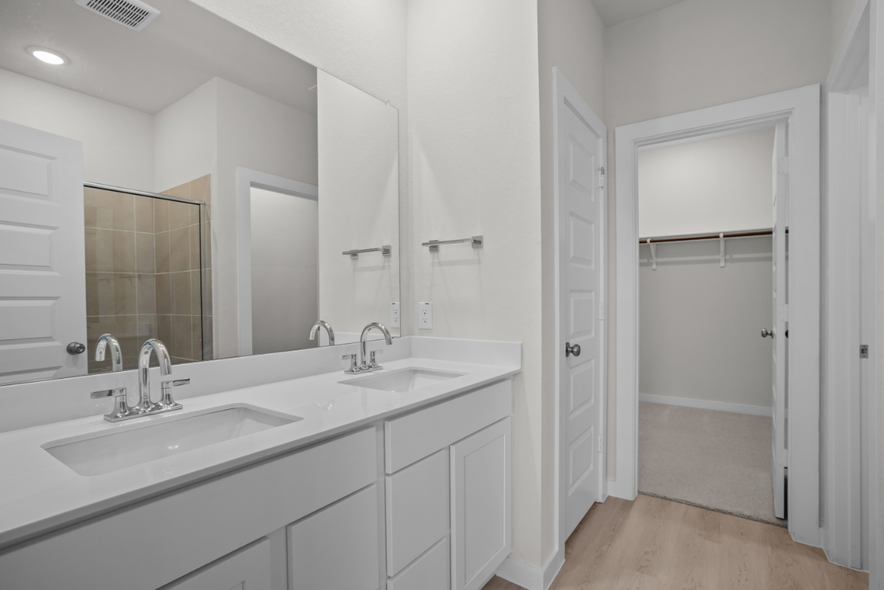 A bathroom with white cabinets.