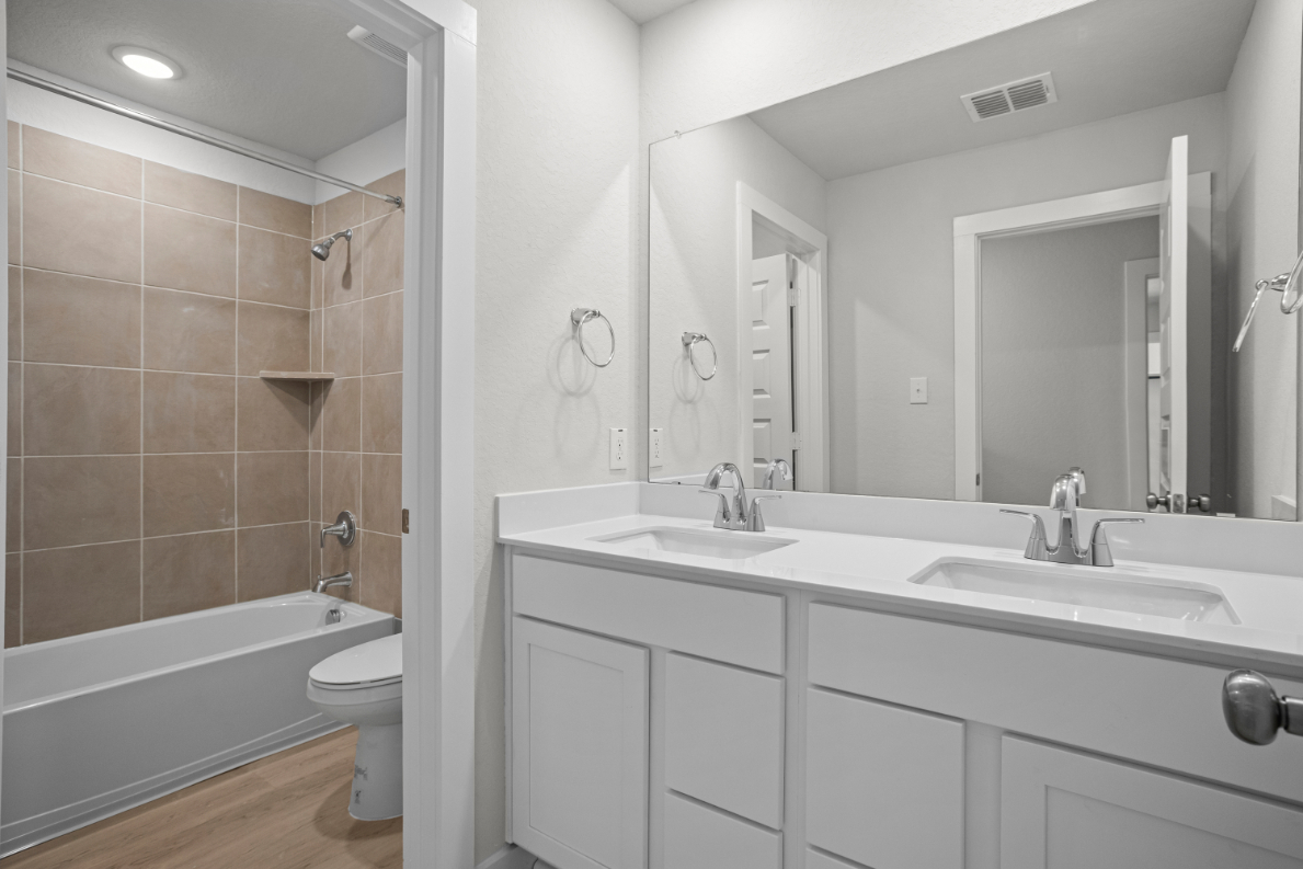 A bathroom with a tub sink and toilet.