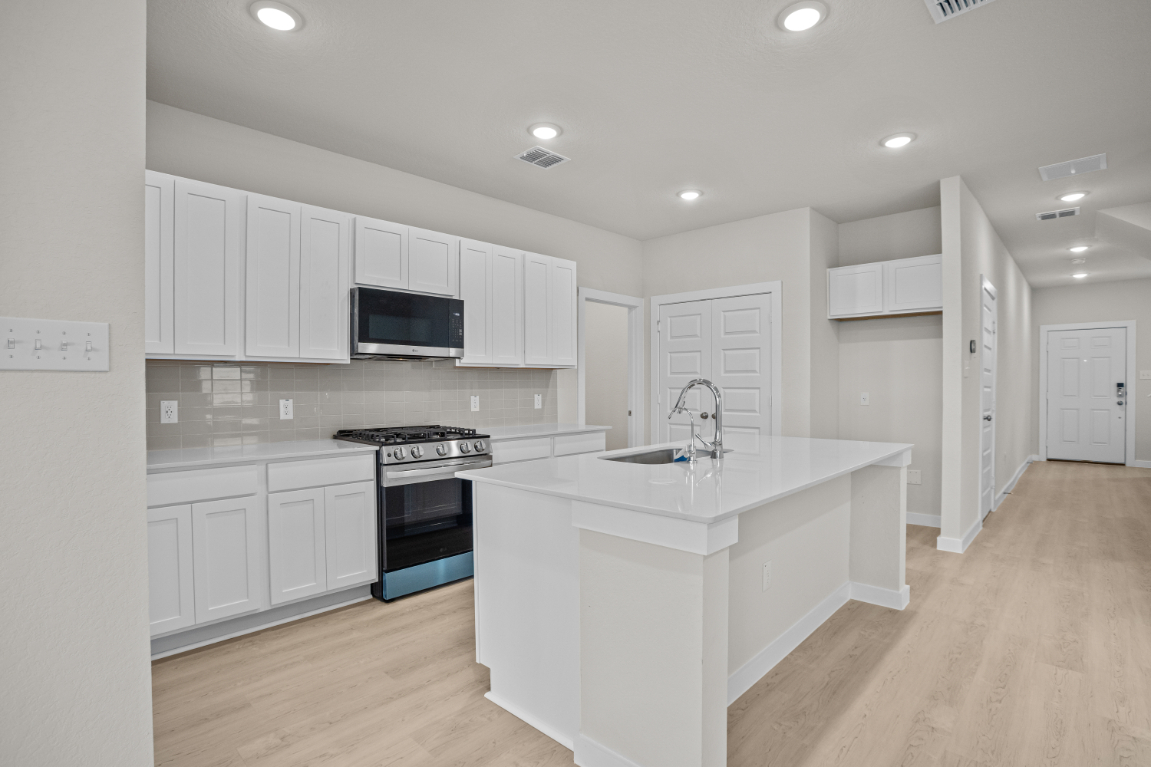 A kitchen with white cabinets.