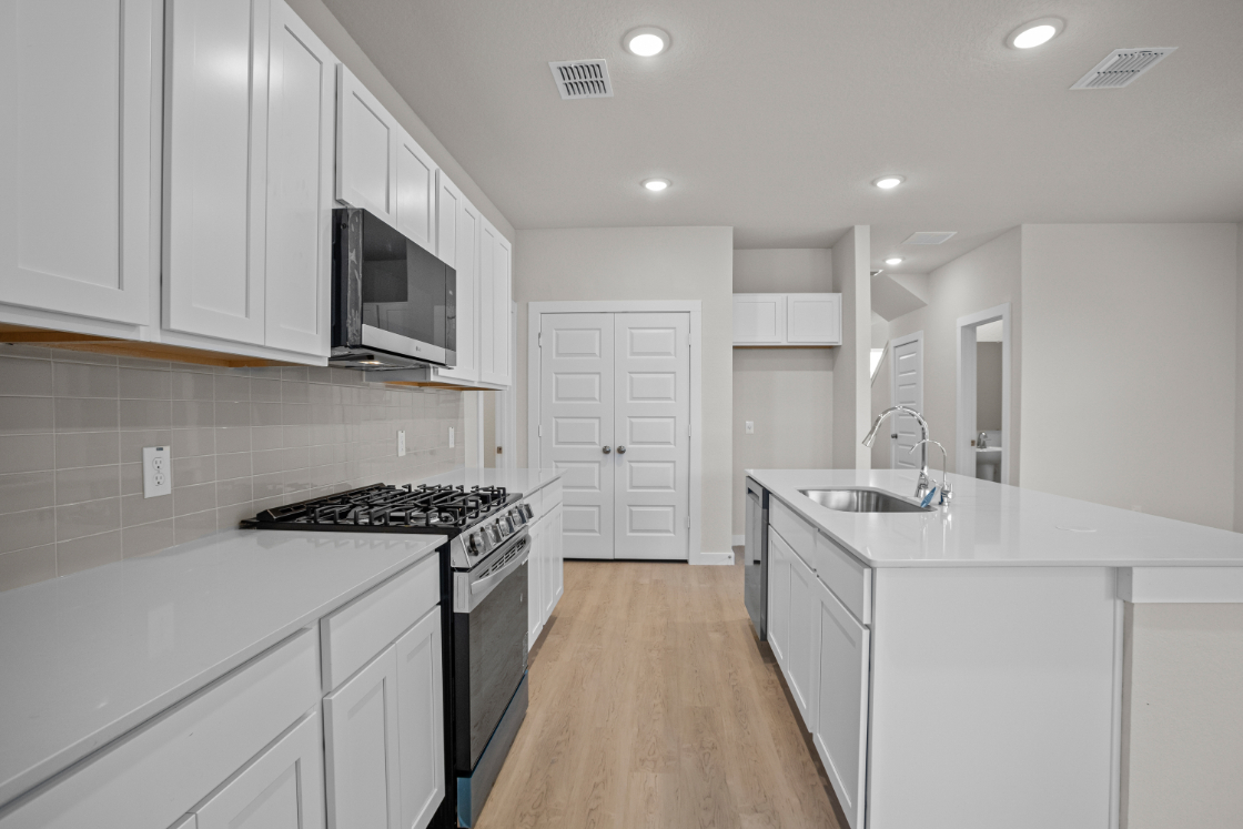 A kitchen with white cabinets.