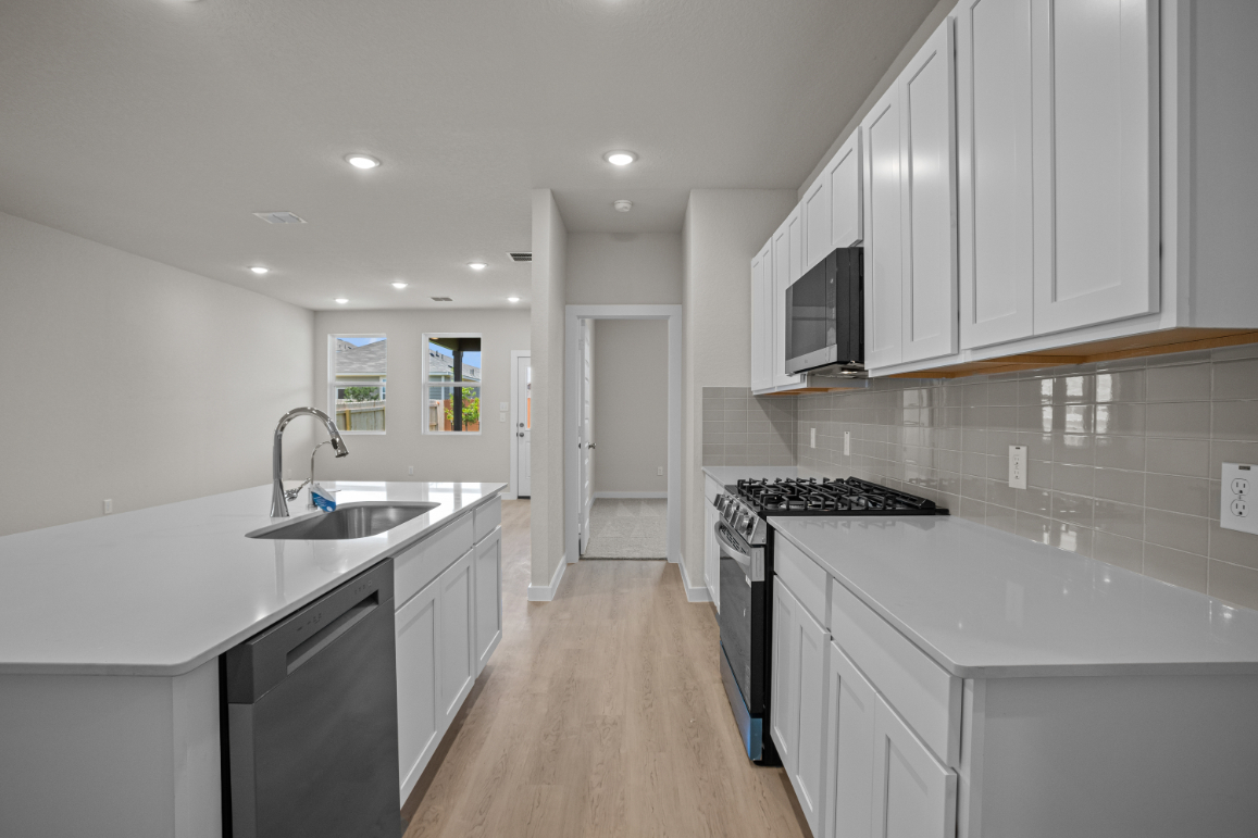 A kitchen with white cabinets.