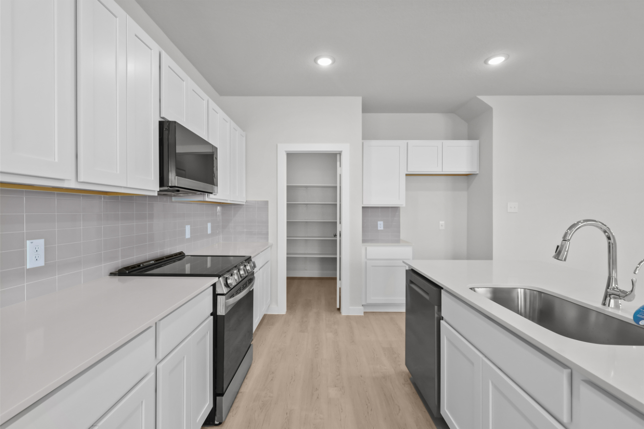 A kitchen with white cabinets.