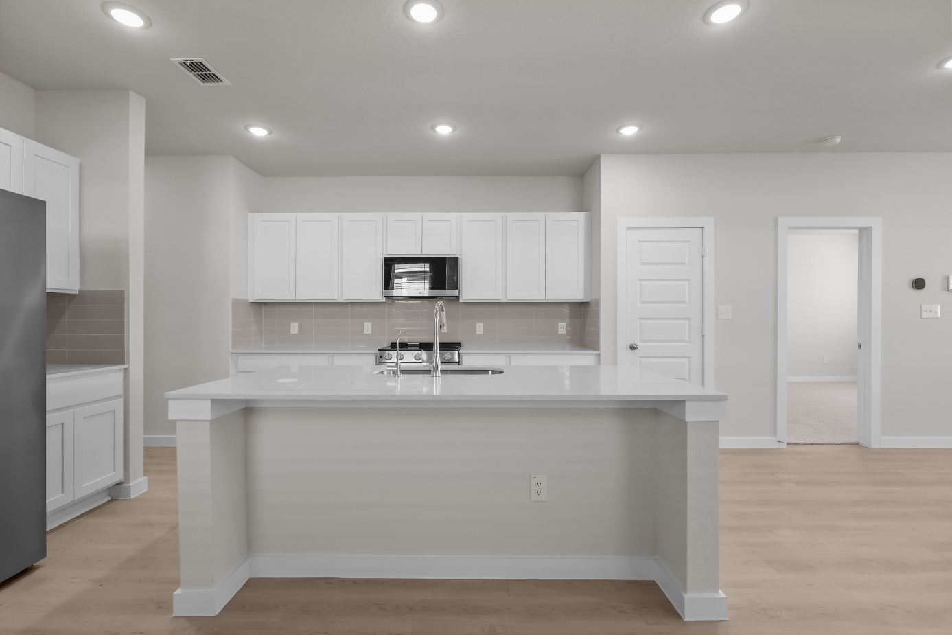 A kitchen with white cabinets.