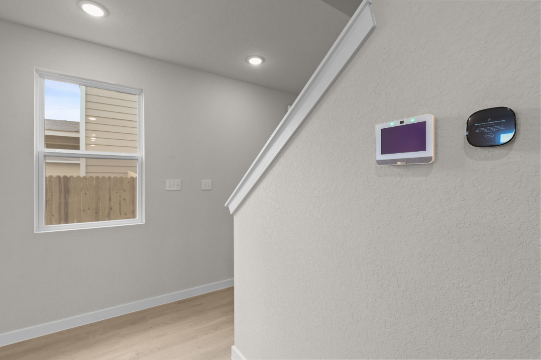 A room with a window and a computer on the wall.