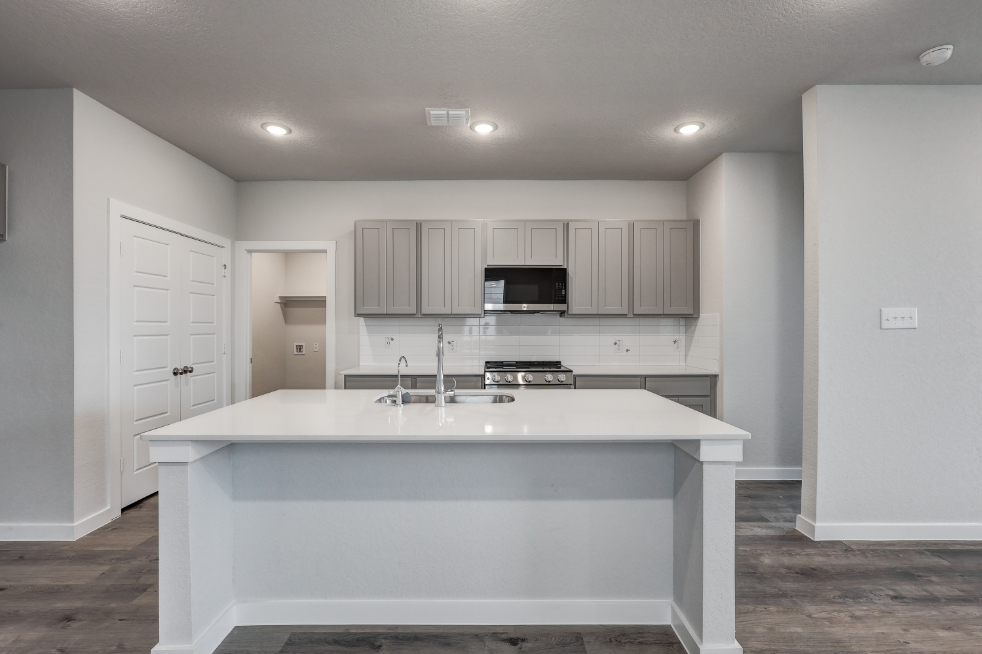 A kitchen with white cabinets.