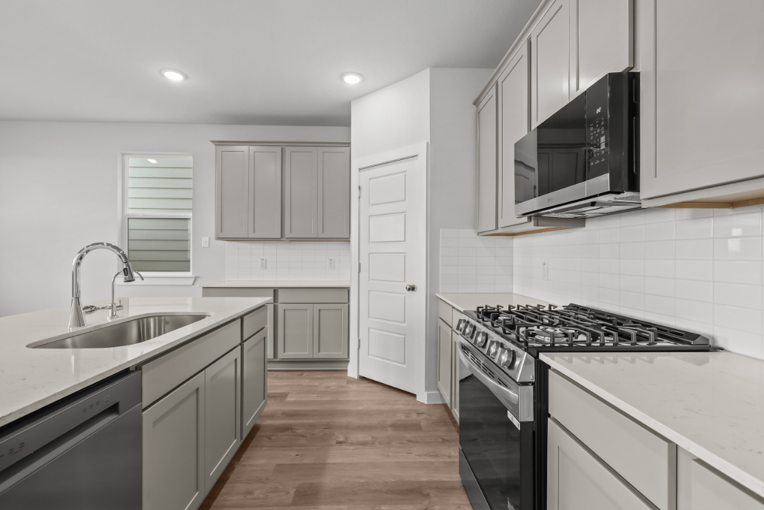 A kitchen with white cabinets.