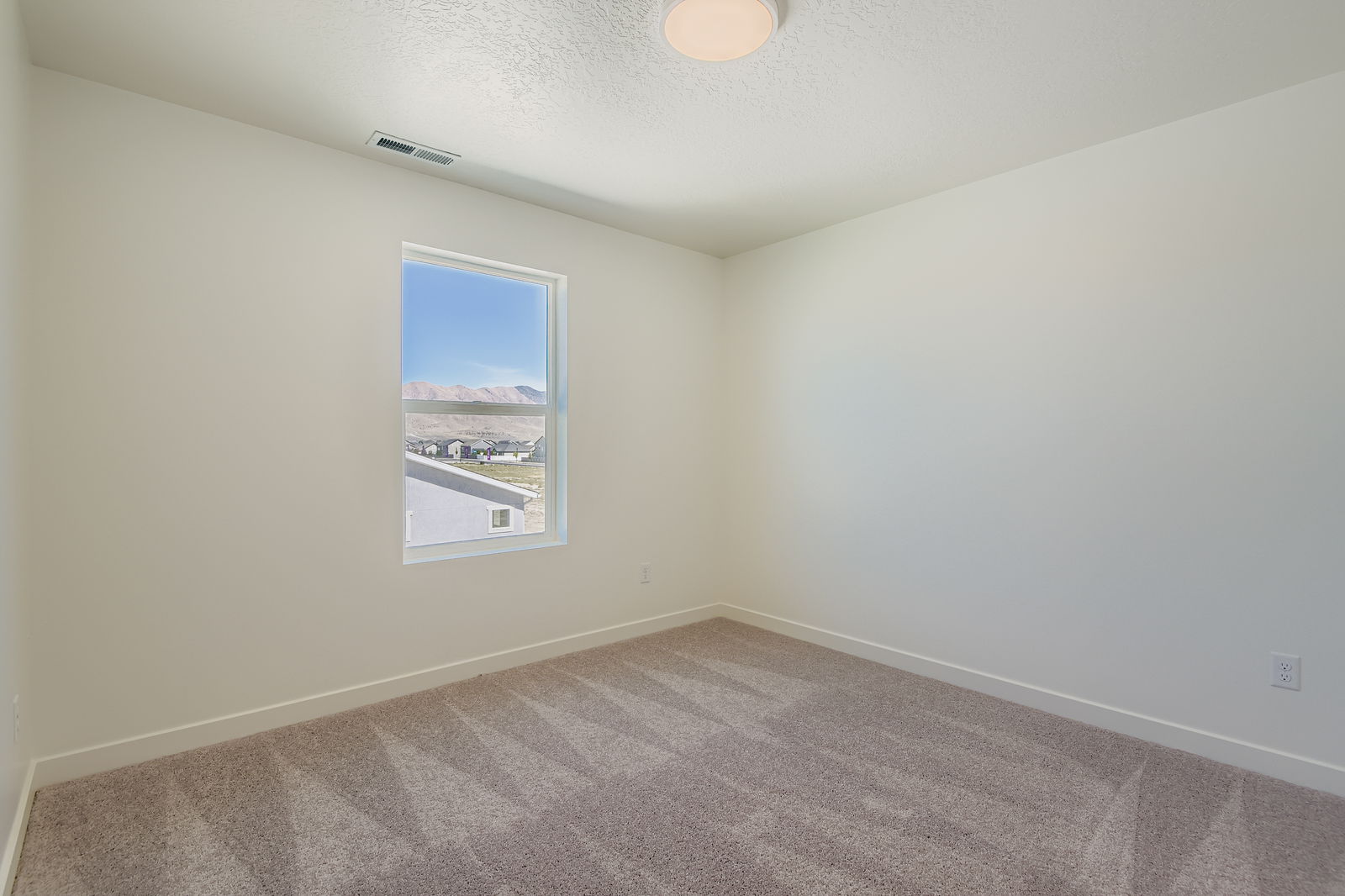 A room with a window and a carpet.