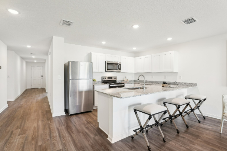 A kitchen with white cabinets.