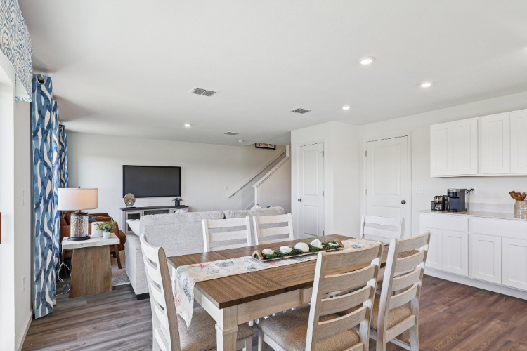 A kitchen with a table and chairs.