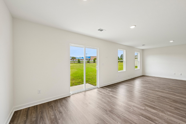 A room with a wood floor and windows.