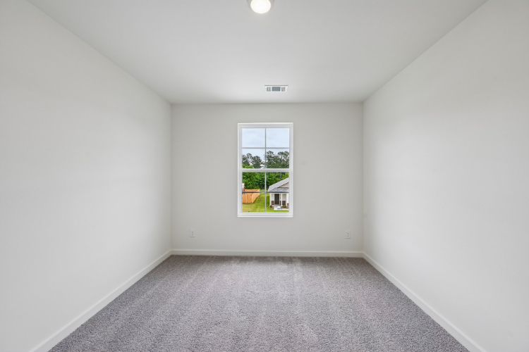 A room with a window and a carpet.