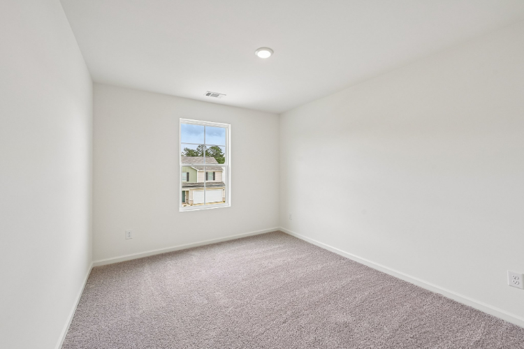 A room with a window and carpet.