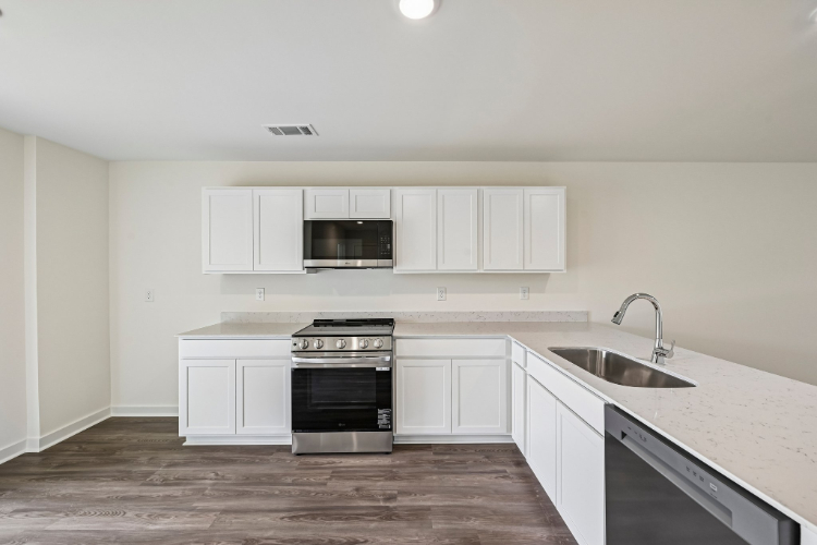 A kitchen with white cabinets.